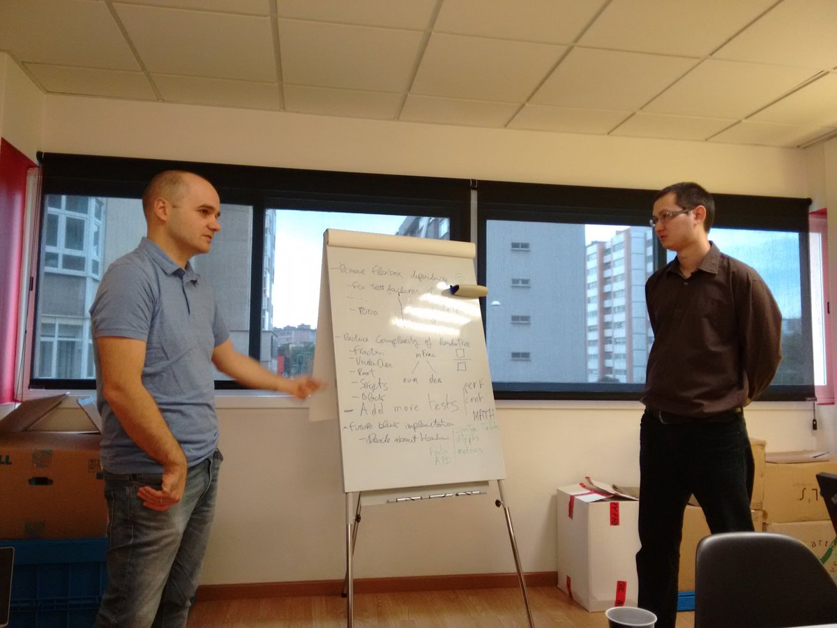 Picture of Alex Garcia and Fred Wang discussing things in a whiteboard during the MathML session